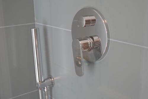 La salle de bains est pourvue d'une douche avec un pommeau de douche en chrome. dans l'établissement Palazzo Manzoni Apartments, à Bari