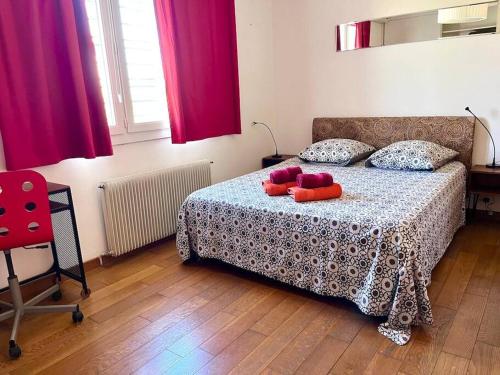 een slaapkamer met een bed met rode kussens erop bij Charmante villa avec piscine et jardin paysagé in Le Crès