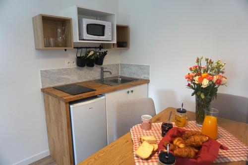 una cucina con tavolo e piatto di cibo di Riva Cottage a Saint-Aignan