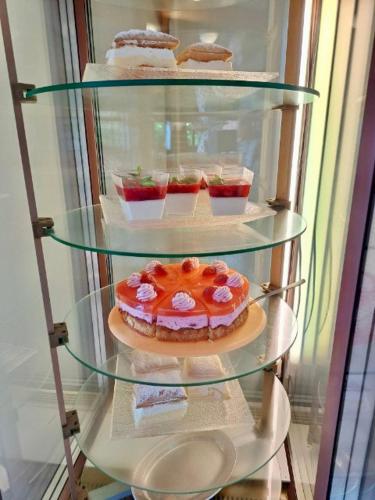 a glass shelf with cakes and other desserts in a refrigerator at Svycarska Bouda in Špindlerův Mlýn