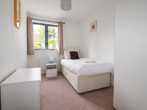 a small bedroom with a bed and a window at Spinnaker in St Austell
