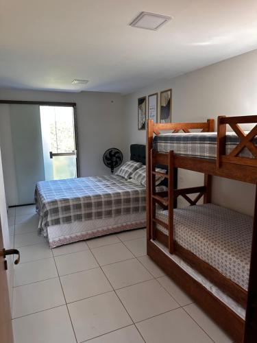 a bedroom with two bunk beds and a window at Flat no Condomínio Paraíso Serra Negra - A 200m da Bodega de Véio in Bezerros