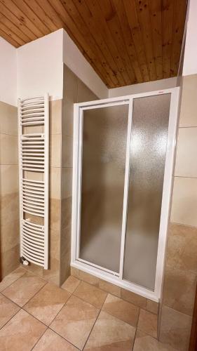 a shower with a glass door in a bathroom at SnežienkaD in Smokovce