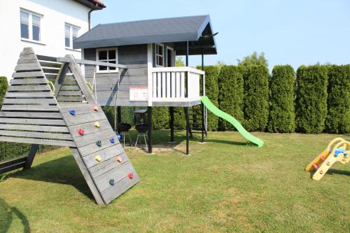 a playground with a slide and a play structure at Albatros in Gąski