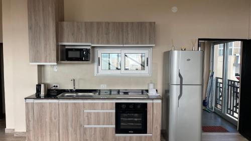 a kitchen with a white refrigerator and a sink at Edificio Itasu - 3ro - alquileres temporales in Posadas