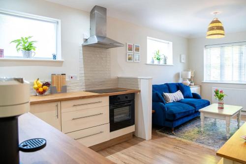 uma cozinha e sala de estar com um sofá azul em No.51 em Lymington