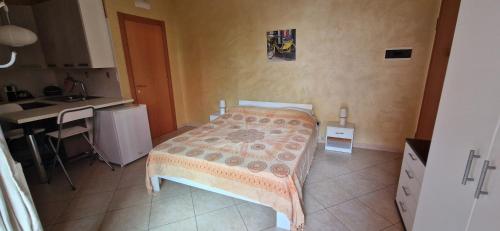a small bedroom with a bed and a kitchen at Sotto l'arco 2 in Sammichele di Bari