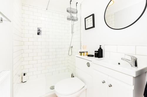 een witte badkamer met een toilet en een wastafel bij Boutique Basement 1 Bed Flat, central location, free parking, Wi-Fi, Sky, Netflix in Leamington Spa
