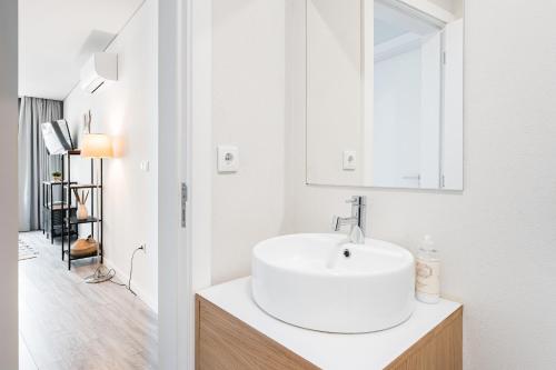 Baño blanco con lavabo y espejo en General Torres Apartments en Vila Nova de Gaia