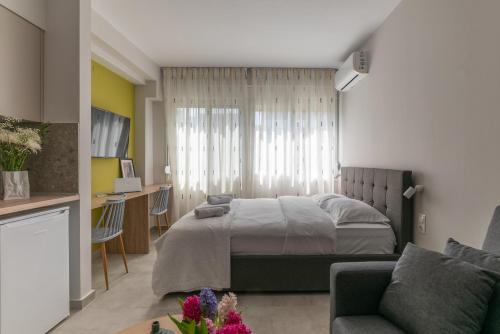 1 dormitorio con cama, escritorio y sofá en Koup Collection Suites, en Tesalónica
