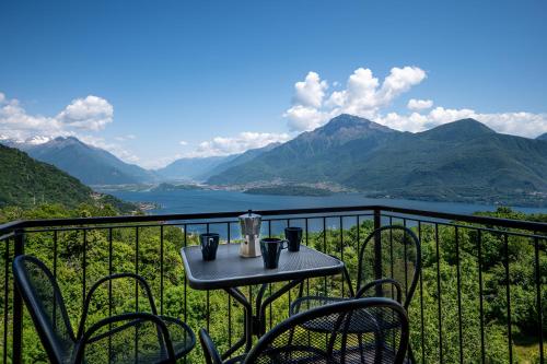 a table and chairs on a balcony with a view of a lake at Agribenessere Brenzio in Consiglio di Rumo
