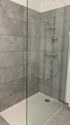 une douche avec une porte vitrée dans une salle de bain dans l'établissement Duplex Horizon vue mer, à Pietrosella
