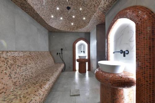 uma casa de banho com um sofá grande e um lavatório em Royal Wellness and Spa em Ruma