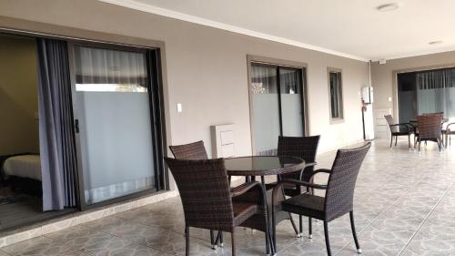a dining room with a table and chairs at Atlantic Pearl Guest House Midrand in Midrand