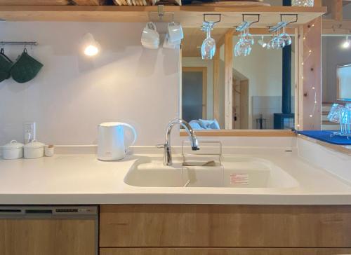 a kitchen counter with a sink and a mirror at Garni MonyaMonya/ガルニモニャモニャ in Hokuto