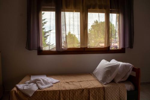 a bed in a room with a window at Efi's Guest House in Agios Dimitrios