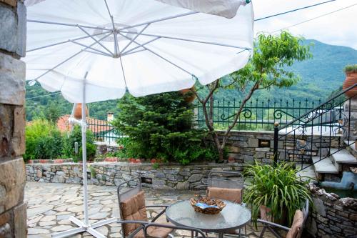 a table with an umbrella on a patio at Efi's Guest House in Agios Dimitrios