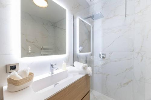 a white bathroom with a sink and a mirror at Maison Tropézienne en plein centre avec jardin et piscine in Saint-Tropez
