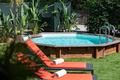 - une piscine avec deux chaises dans la cour dans l'établissement Maison Tropézienne en plein centre avec jardin et piscine, à Saint-Tropez