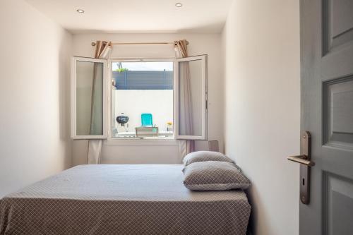 um quarto com uma cama e uma janela aberta em Maison de vacances em La Ciotat