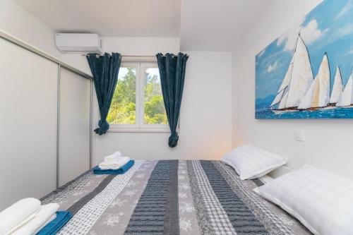 a bedroom with a bed with a painting of sailboats at Apartment ACI Marina MILNA Brač in Milna