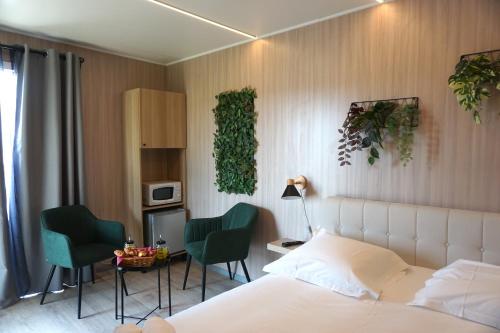 1 dormitorio con 1 cama, 2 sillas y microondas en Riva Kub, en Saint-Aignan