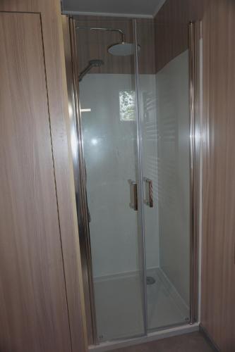 une douche avec une porte vitrée dans une salle de bain dans l'établissement Riva Kub, à Saint-Aignan