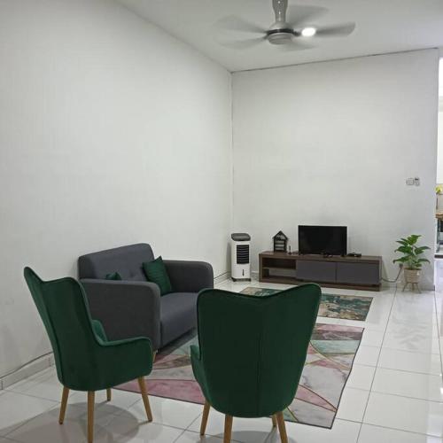 uma sala de estar com um sofá e duas cadeiras em Damai Homestay em Kepala Batas