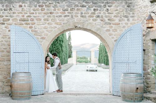 a bride and groom standing in an archway at Château Saint-Pierre de Mejans in Puyvert