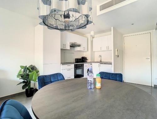 - une table dans la cuisine avec une bouteille d'eau dans l'établissement 2p Cannes centre-ville Terrasse, à Cannes