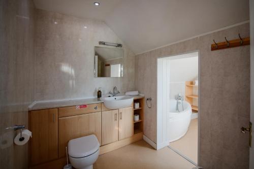 a bathroom with a sink and a toilet and a tub at Beldon House in Brigg