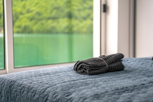 Happyland Villa, Jablanica في Jablanica: لفة من الحبل تجلس على سرير مع نافذة
