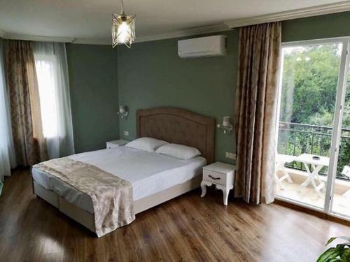 a bedroom with a bed and a large window at Къща за гости НЕЛ in Chernomorets