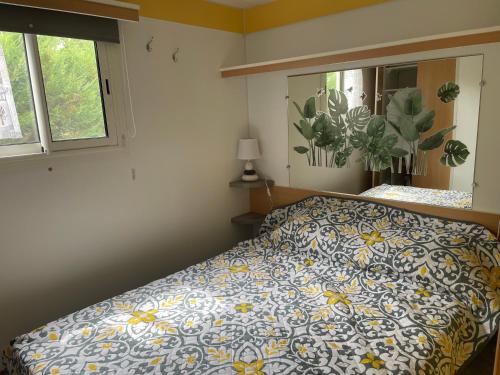 - une chambre avec un lit doté d'une couette bleue et jaune dans l'établissement Mobilhome à Sainte Croix Du Verdon, à Sainte-Croix-de-Verdon