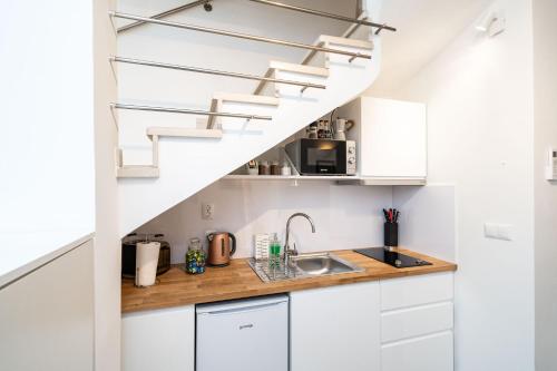 une cuisine avec des placards blancs et un escalier dans l'établissement Dubrovnik Gate Apartments, à Dubrovnik