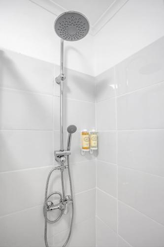 a shower with a shower head in a bathroom at Almada Apt - Balcony with River View by Lisbeyond in Almada