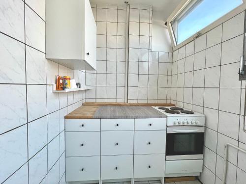 uma cozinha branca com um fogão e uma janela em Monteurwohnung in Stadtnähe em Hanôver