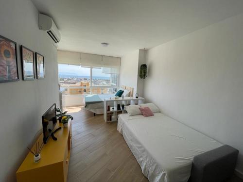 - une chambre avec un lit, un bureau et une table dans l'établissement Estudio con vistas, à Torremolinos