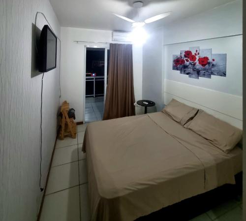 um quarto com uma cama e uma televisão de ecrã plano em Apartamento Barra Sky Vista Mar em Salvador