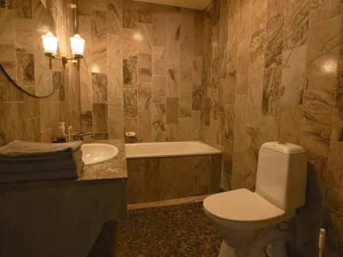 een badkamer met een toilet, een wastafel en een bad bij Myllykosken Kerho Oy in Kouvola