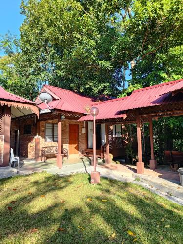 a house with a red roof and a yard at D'Impiana Riverview Chalet # Lenggong in Kampong Ulu Jepai