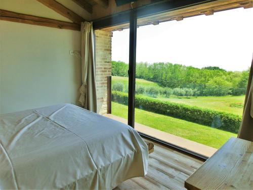 a bedroom with a bed and a large window at Agriturismo Dolce Colle in Volpago del Montello