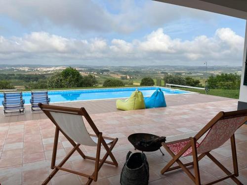 a patio with two chairs and a swimming pool at Casa do Horizonte in Bombarral