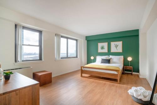 a bedroom with a bed with a green wall at Beacon Hill 2BR wGreat Views Gym Doorman BOS-54 in Boston