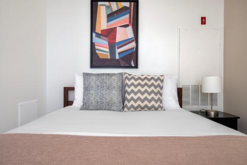 a bedroom with a white bed and a painting on the wall at South Boston studio w wd nr red line BOS-887 in Boston
