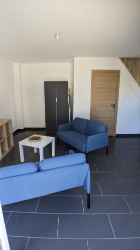 un salon avec deux canapés bleus et une table dans l'établissement Chambre urbaine dans Maison Moderne, à Dammarie-les-Lys