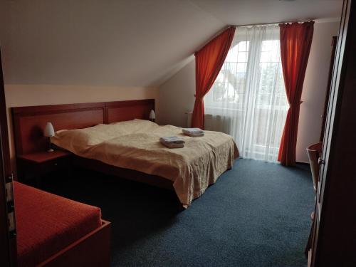 美國魯穆尼卡的住宿－Villa Cassandra，一间卧室配有床和红色窗帘的窗户