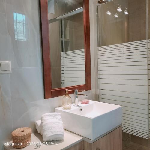 a bathroom with a white sink and a mirror at Bay Villas Lefokastro in Lefokastro