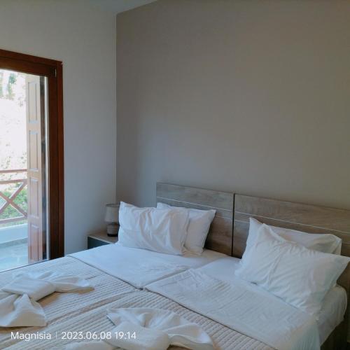 a bedroom with a large bed with white sheets and pillows at Bay Villas Lefokastro in Lefokastro