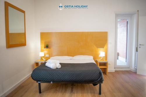 1 dormitorio con 1 cama con 2 toallas en Appartamento Tristano e Isotta, en Lido di Ostia